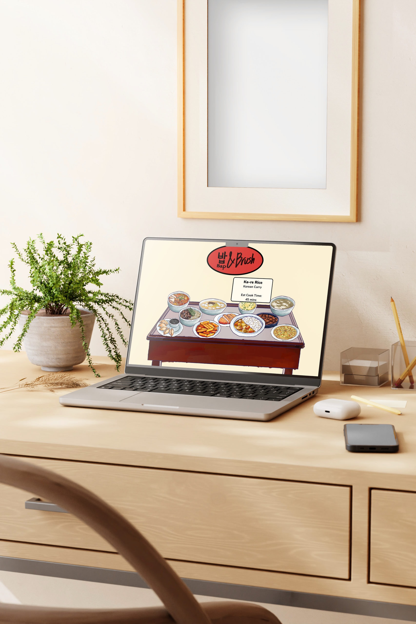 A laptop on a pale wooden desk beside a potted plant and a framed print, its screen showing the Bap & Brush site: a Korean wordmark above a top-down illustration of a tray of small dishes.