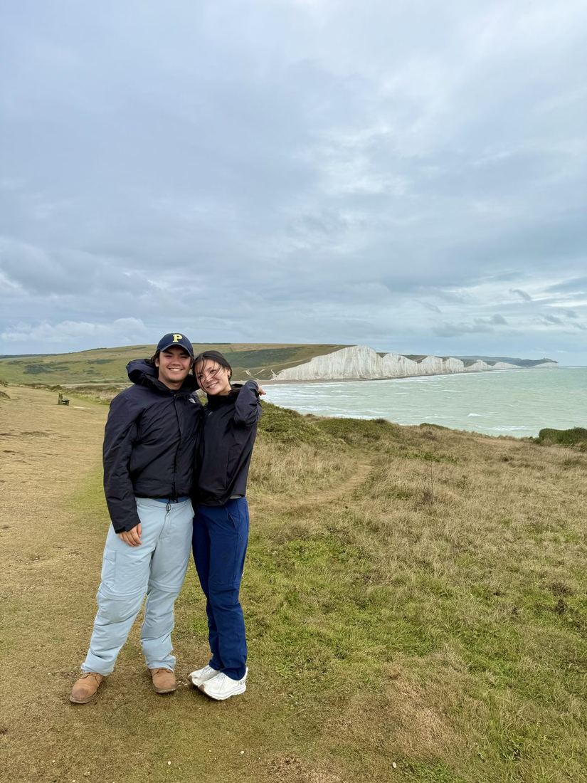 Gabe and Hannah on a clifftop, with the white Seven Sisters cliffs behind them.